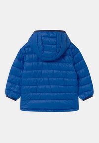 Veste matelassée bleue avec capuche, présentant des lignes horizontales cousues, des poignets élastiqués et une texture lisse et brillante.