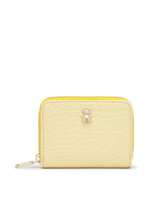 Cartera texturizada de color amarillo pálido, con cremallera perimetral, ribete dorado y un pequeño cierre con forma de oso, sobre un fondo blanco.