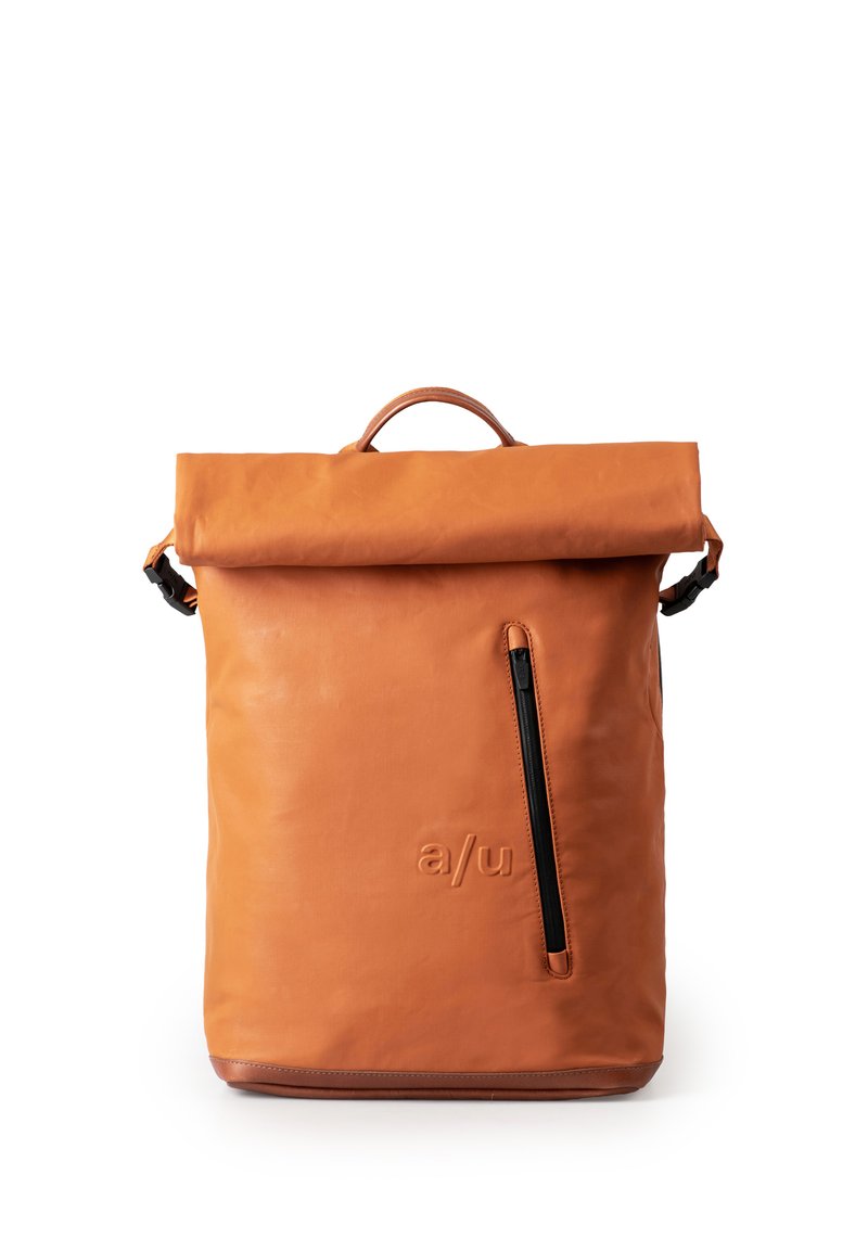 Zaino in pelle arancione con parte superiore arrotolata, tasca frontale con zip e logo in rilievo discreto. Texture liscia con dettagli in metallo nero.
