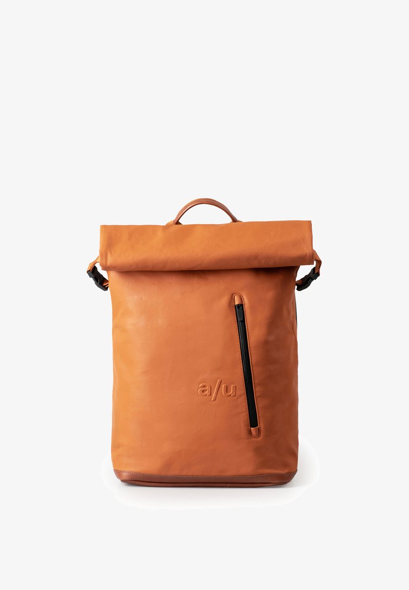 Oranje leren rugzak met een opgerolde bovenkant, voorzak met ritssluiting en subtiele gegraveerde logo. Glad textuur met zwarte hardware accenten.