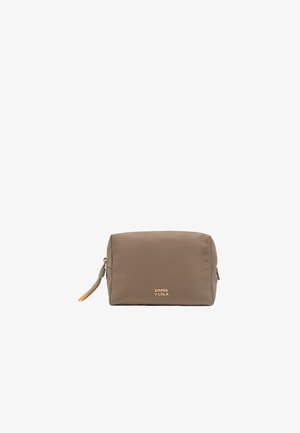 Trousse de maquillage en nylon marron de forme rectangulaire, dotée d'un logo doré, d'une fermeture éclair et d'un pompon décoratif avec des accents verts et orange.