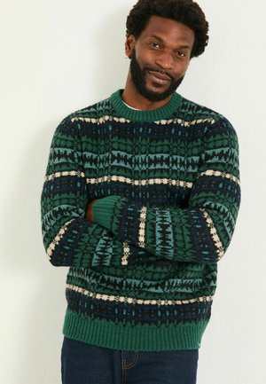 Strickpullover in Dunkelgrün und Marineblau mit cremefarbenen Akzenten. Verfügt über ein geometrisches Muster sowie gerippte Säume und einen Halsausschnitt. Warm und mit strukturierter Oberfläche.