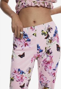 Pantaloni floreali rosa con motivi vivaci di farfalle e fiori, dotati di una vita elastica per una vestibilità comoda.