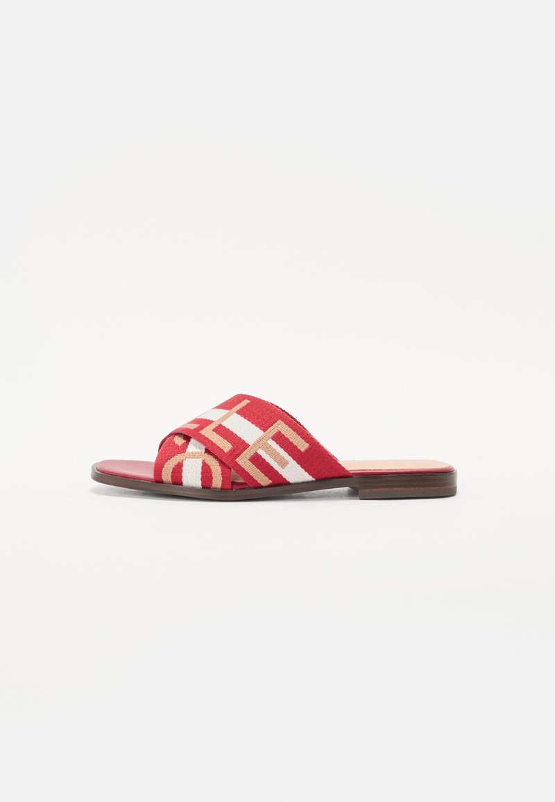 Rood en wit gestreepte schuifsandaal met een kruisbandontwerp. Heeft een platte houten hak en een gladde stoffen bovenkant.