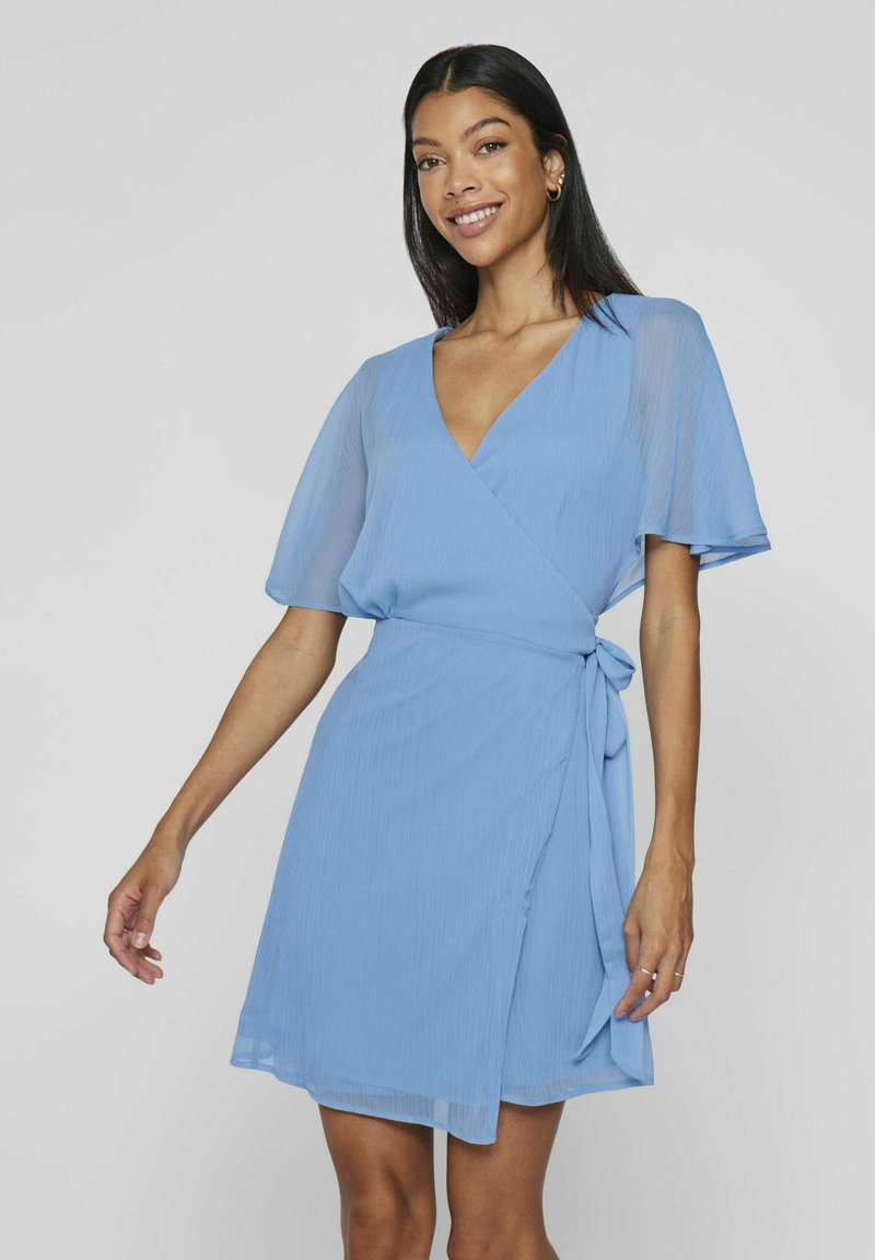 Svetlomodré zavinovacie šaty s krátkymi širokými rukávmi, véčkovým výstrihom, textúrovou látkou a bočným viazaním v páse.
