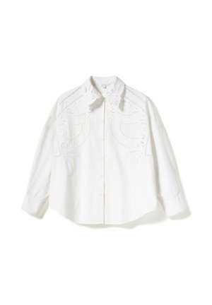 Fehér pamut ing, finom hímzett részletekkel a vállakon, klasszikus gallérral és hosszú ujjakkal, gombos elülső résszel.