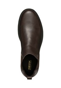 Botas Chelsea de cuero marrón con un acabado suave, panels laterales elásticos, punta redonda y suela de goma negra en contraste. Logo dorado en la plantilla.