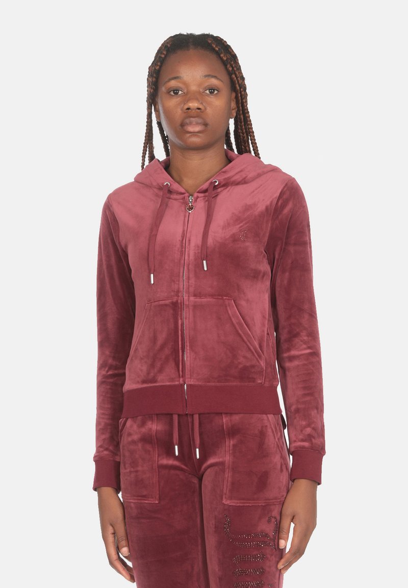 Felpa con zip in velluto bordeaux, dotata di tasca frontale, cappuccio con cordino e polsini a coste. Presenta un discreto dettagli del logo.