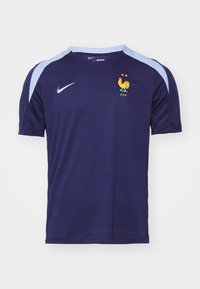 Pánský fotbalový dres Nike v hlubokém námořnickém modrém s světlomodrými akcenty na ramenech a francouzským znakem se slepicí a hvězdami. Design s krátkým rukávem.