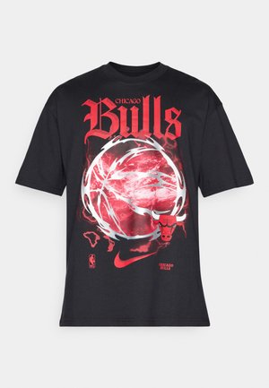 Camiseta negra que presenta "Chicago Bulls" en negrita y en color rojo, un diseño gráfico de baloncesto y el logo de los Bulls en la parte inferior. Fabricada en algodón.