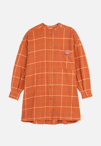 Chemise à carreaux orange avec un devant boutonné, des manches longues et une poche poitrine avec une étiquette. Le matériau semble doux et texturé.