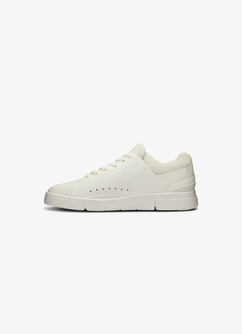 Weißer Sneaker mit einem glatten Lederobermaterial, strukturierten Mesh-Akzenten, perforierten Details, leicht erhöhten Sohle und flachen Schnürsenkeln.