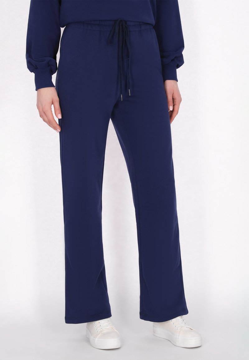 Pantalones jogger azul marino fabricados con tela suave, que cuentan con una cinturilla elástica con cordón y bolsillos laterales.