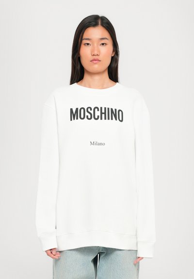Hvid sweatshirt med "MOSCHINO" og "Milano" trykt i sort. Har lange ærmer, rund hals og en afslappet pasform. Glat tekstur.