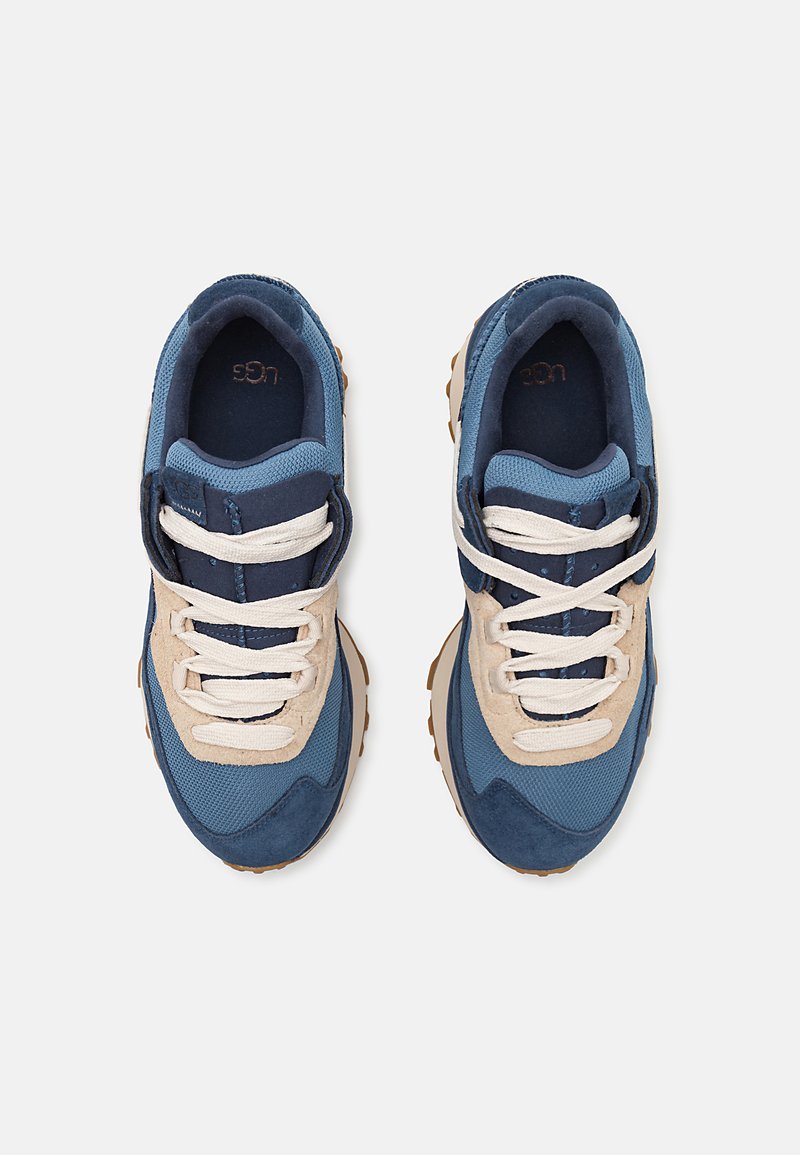 Blauwe en beige sneakers van mesh en suede materialen, met een gestructureerde zool, ronde veters en logodetail op de tong.
