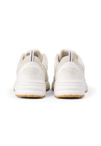 Scarpe sportive bianche con una tomaia in mesh testurizzato, suola ammortizzata e suola esterna in gomma marrone chiaro. Logo Fila impresso sul tallone.
