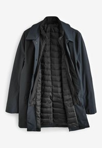 Cabană albastră marină cu o căptușeală interioară ușoară, quilted. Dispune de un guler, butoane frontale și două buzunare laterale. Tesătură exterioară netedă.