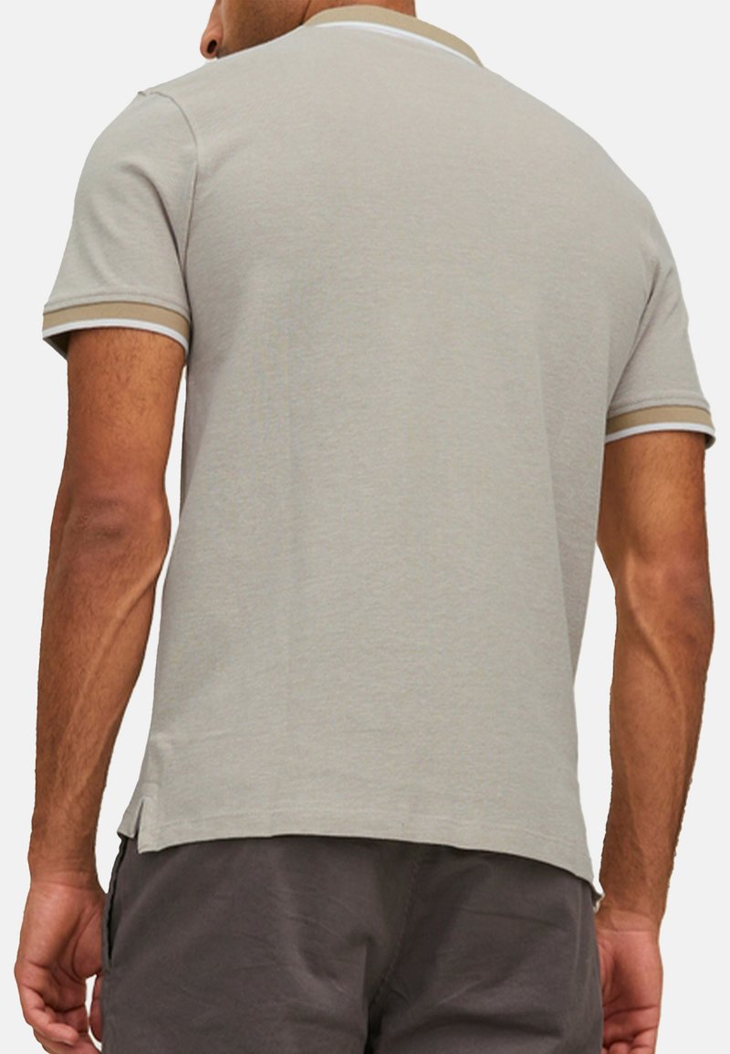 Grå polo t-shirt med korte ærmer, kontrasterende beige og hvide striber på kraven og ærmerne, lavet af blødt bomuldsstof.
