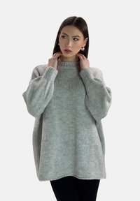 Suéter de punto sobre tamaño en gris claro, con cuello acanalado y mangas abullonadas, que presenta un patrón texturizado y un corte holgado.
