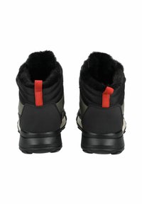 Zapatos negros y verdes de media altura con parte superior texturizada, forro de piel sintética y una lengüeta roja. Cuentan con una suela de goma robusta para mayor tracción.