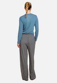 Lichtblauw langexemplaar shirt gemaakt van zachte stof, gecombineerd met kleurrijke gestreepte wide-leg broek met een ontspannen pasvorm en elastische tailleband.