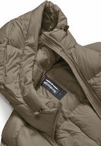 Khaki pufferjack met een gewatteerd ontwerp, voorzien van een hoge kraag, ritssluiting en label aan de binnenkant. Glad, waterafstotend materiaal.
