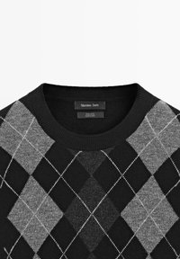 Black and gray argyle wool sweater with a round neckline, featuring diamond patterns and contrasting white stitching. Brand label visible.