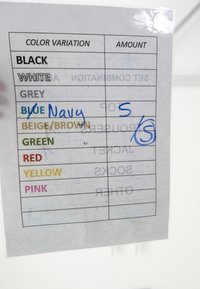 Tabelle mit Farbvariationen und handschriftlichen Notizen, die "Navy" neben Blau sowie die Zahlen "5" und "5/5" in der Mengenspalte angeben.