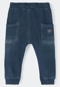 Marineblauwe joggingsbroek met elastische tailleband, ribgebreide boorden, twee zijzakken en een stoffen label op de linkerzak. Zachte textuur.