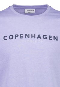 Vaalean violetin värinen t-paita, jossa on pyöreä kaula-aukko. Paidassa on suurilla mustilla kirjaimilla teksti "COPENHAGEN" ja pienemmällä harmaalla fontilla "LINDBERGH". Rennon mallinen.