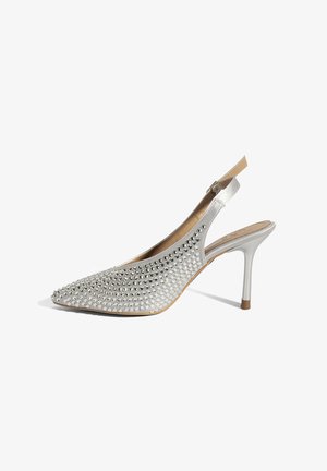 Zilveren slingback damesschoen met hoge hak en puntige neus, versierd met strass-steentjes op het bovendeel en een slanke, metalen hak.
