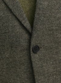 Veste texturée gris-vert avec un motif chevron, dotée d'un bouton noir et de revers crantés pour un design ajusté.