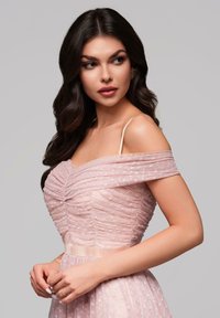 Robe rose clair décolettée avec un corsage froncé et une texture à pois, dotée d'une superposition en voile et d'une taille cintrée.