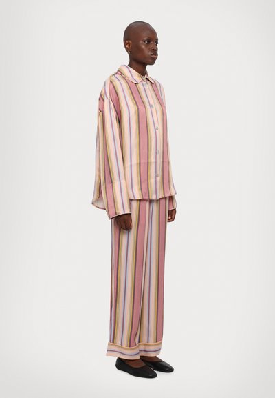 Striped pajama set in pink, cream, and pastel colors. Loose-fitting shirt with a collar, button front, and wide-legged pants. Soft fabric.