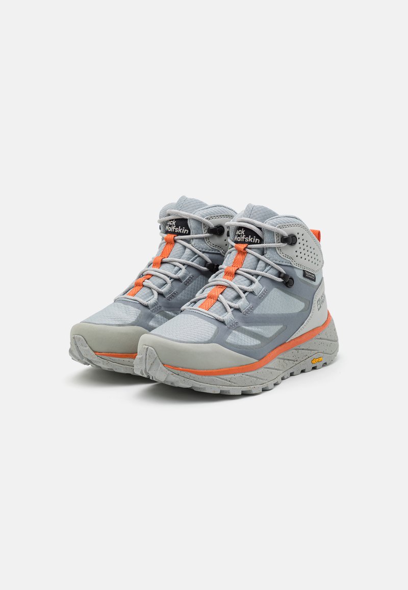Ein Paar graue und orange Wanderschuhe in mittlerer Höhe mit strukturierten Sohlen und dem "Jack Wolfskin"-Logo auf der Zunge, rechts geneigt auf einem weißen Hintergrund.