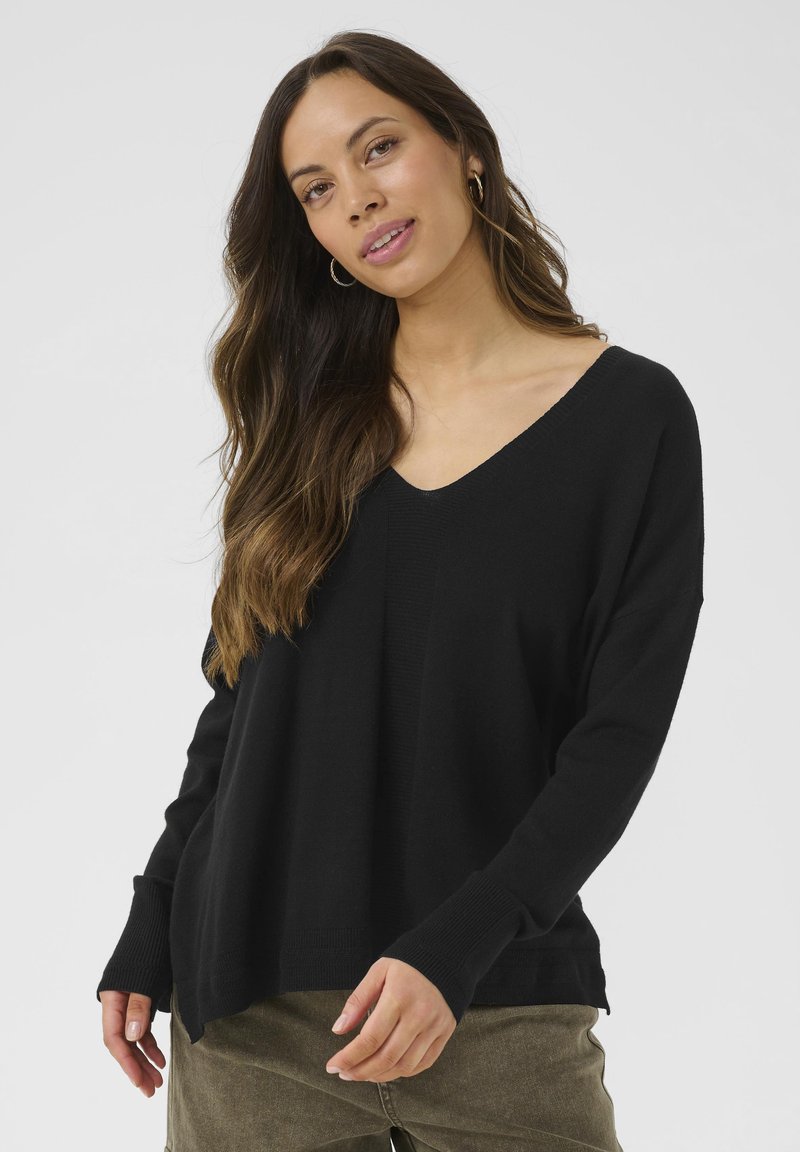 Maglione nero a collo a V con maniche lunghe e polsini a coste. Tessuto morbido e vestibilità rilassata, con un leggero design delle spalle scese.