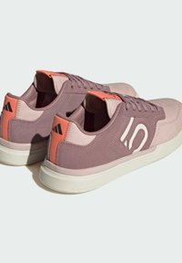 Scarpe da ginnastica viola e rosa con tomaia in suede e tessuto, dettagli testurizzati, logo bianco e suola in gomma. Design del tallone rinforzato.
