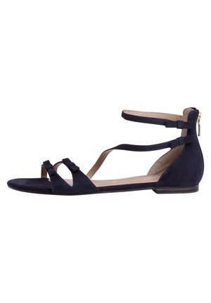 Flad sort sandal i ruskind med to tåremme, ankelrem med spænde og lukkes med lynlås bagpå.