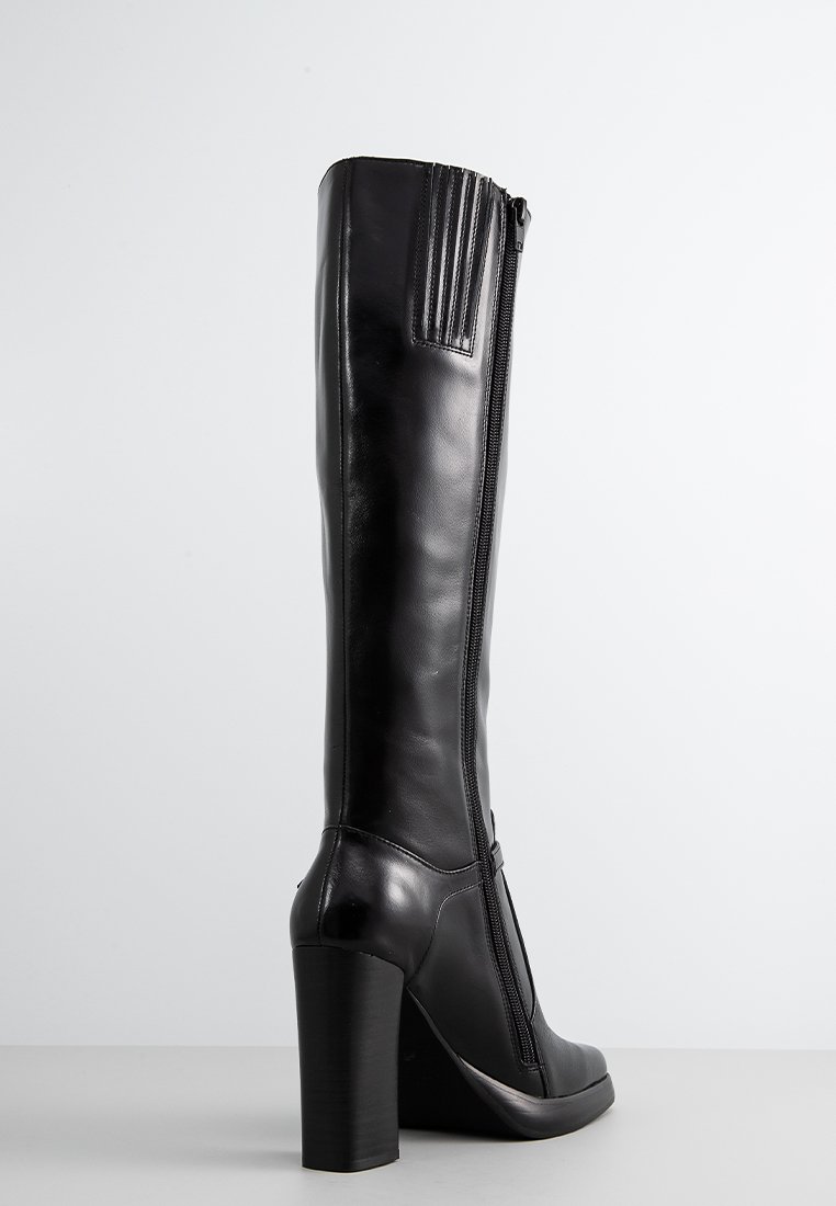 Botte en cuir noire montée jusqu'au genou avec un panneau arrière texturé, un talon bloc haut et une fermeture à glissière sur le côté. Finition lisse avec un minimalisme dans les détails.