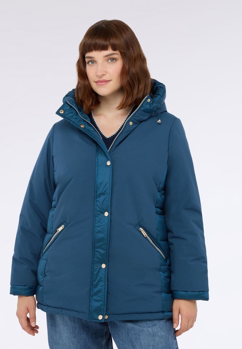 Tyrkysová péřová bunda s kapucí, zlatými patentkami, kapsami na zip a texturovaným povrchem. Pohodlný střih s mírně nadýchanými rukávy.