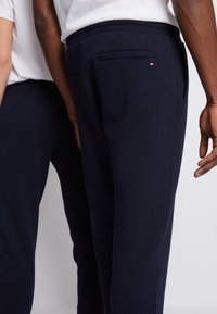 Marineblå sweatpants med en mjuk textur, utrustad med en bakficka och en liten logotyp. Bekväm, avslappnad passform.