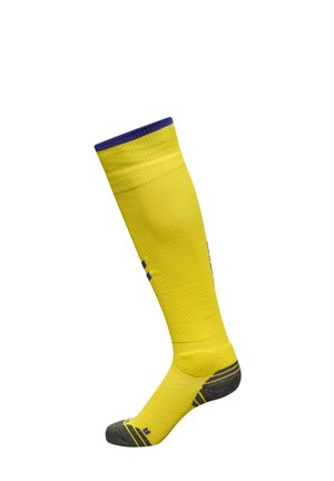 Long yellow sports sock with purple trim at top and gray reinforced toe and heel areas, shown upright on a white background.