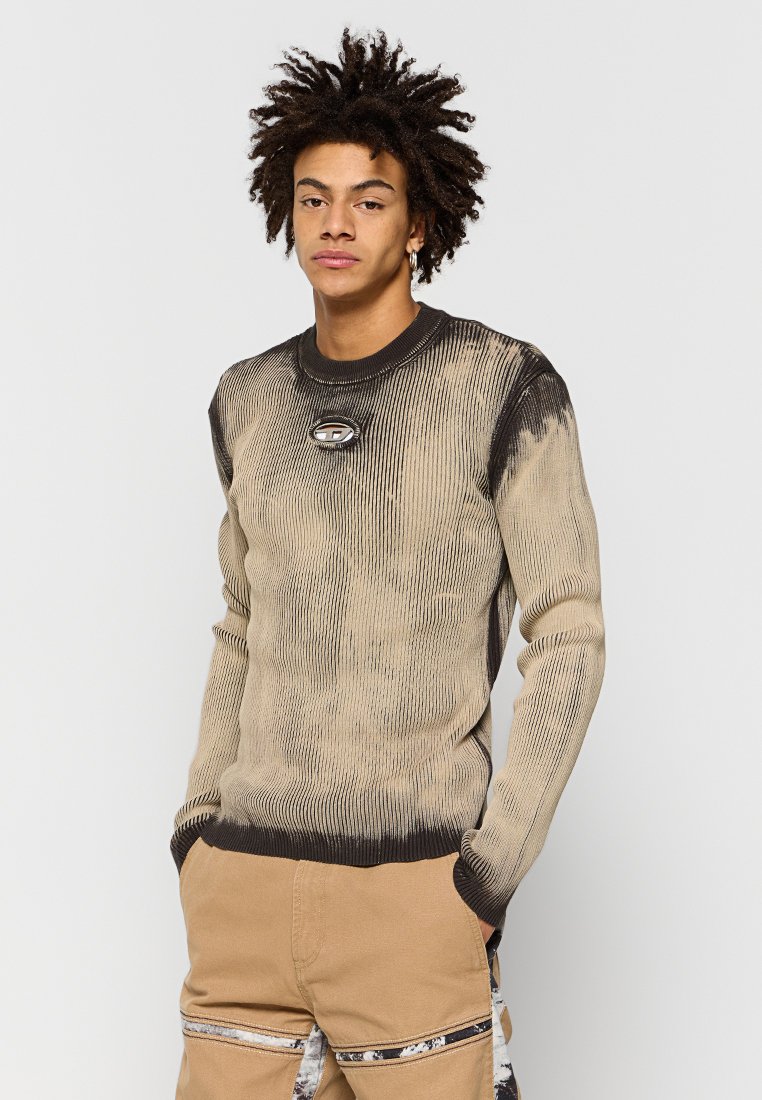 Beiger Strickpullover mit schwarzen Akzenten, der eine gerippte Textur und einen runden Halsausschnitt aufweist. Zeigt ein rundes Logodetail auf der Brust.