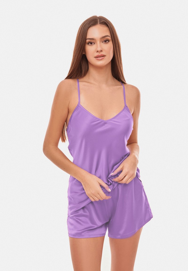 Fioletowy satynowy kombinezon z cienkimi ramiączkami, dekoltem w kształcie litery V i luźnym krojem. Tkanina ma gładką fakturę i delikatny połysk.