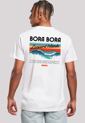 White cotton t-shirt with back graphic featuring "BORA BORA" in bold black letters, multicolored stripes, and wave design.