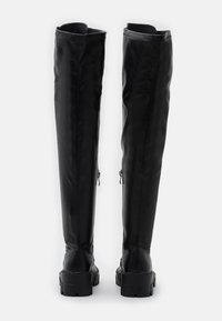 Czarne skórzane kozaki za kolano o gładkiej fakturze, z grubą gumową podeszwą, dwoma bocznymi zamkami i dopasowanym krojem.