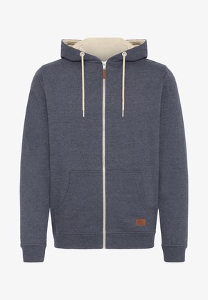 Kapuzensweatshirt mit Reißverschluss aus dunkelblauem Stoff und cremefarbenem Innenfutter. Besitzt eine Fronttasche, beigefarbene Kordeln und ein braunes Lederlogo-Label.