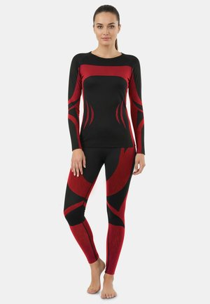 Black and red athletic long-sleeve top and leggings featuring abstract patterns and a fitted design, crafted from stretch fabric.