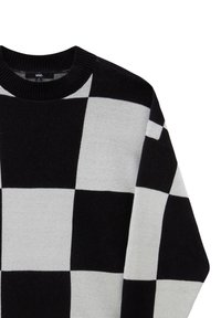 Pull tricot à carreaux noir et blanc avec un col rond côtelé, avec de grands motifs carrés alternés.