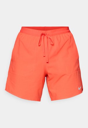 Φωτεινά κοραλλί αθλητικά σορτς με ελαστική μέση και λογότυπο Nike στο κάτω δεξί μέρος του ποδιού, σε απλό φόντο.
